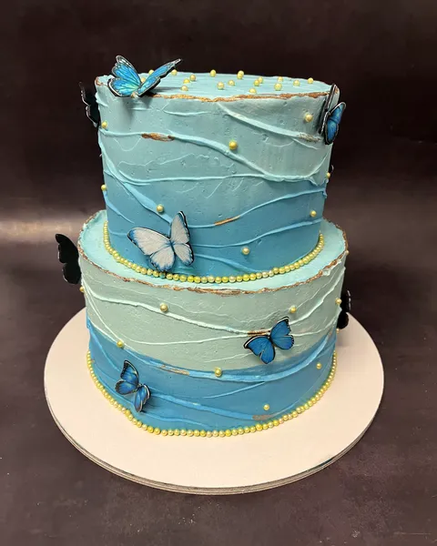 Tarta azul de dos pisos con mariposas