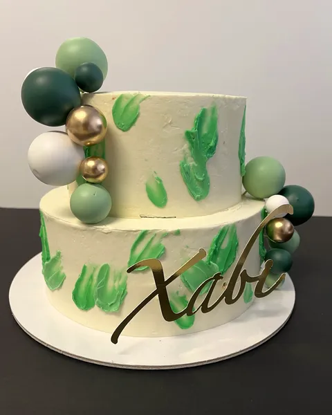 Tarta de dos pisos con esferas verdes y doradas