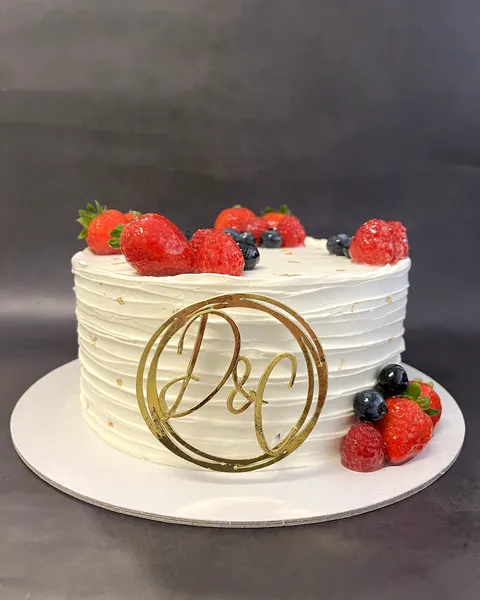 Tarta blanca con fresas e iniciales doradas
