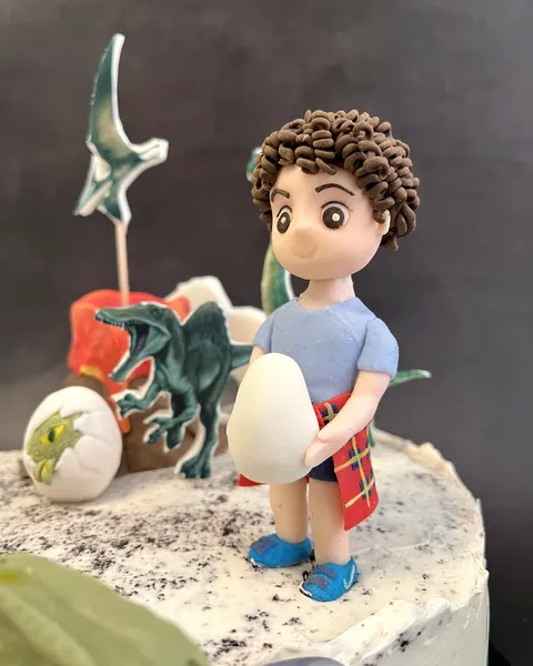 Niño con huevo de dinosaurio de fondant