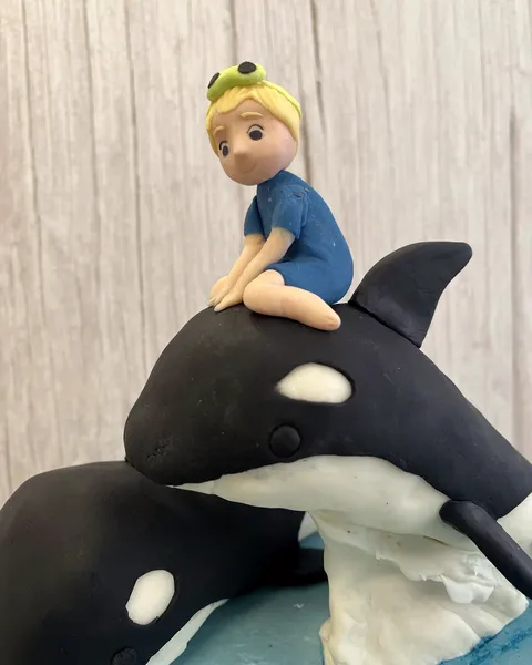 Niño sobre una orca de fondant